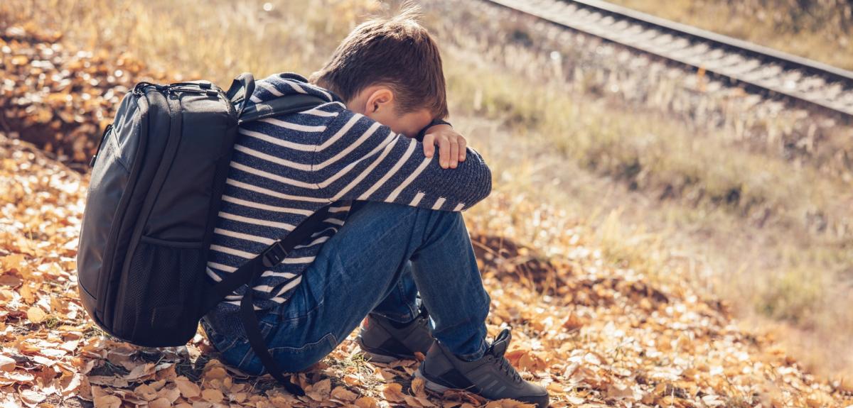 Teenager boy sitting on grass
